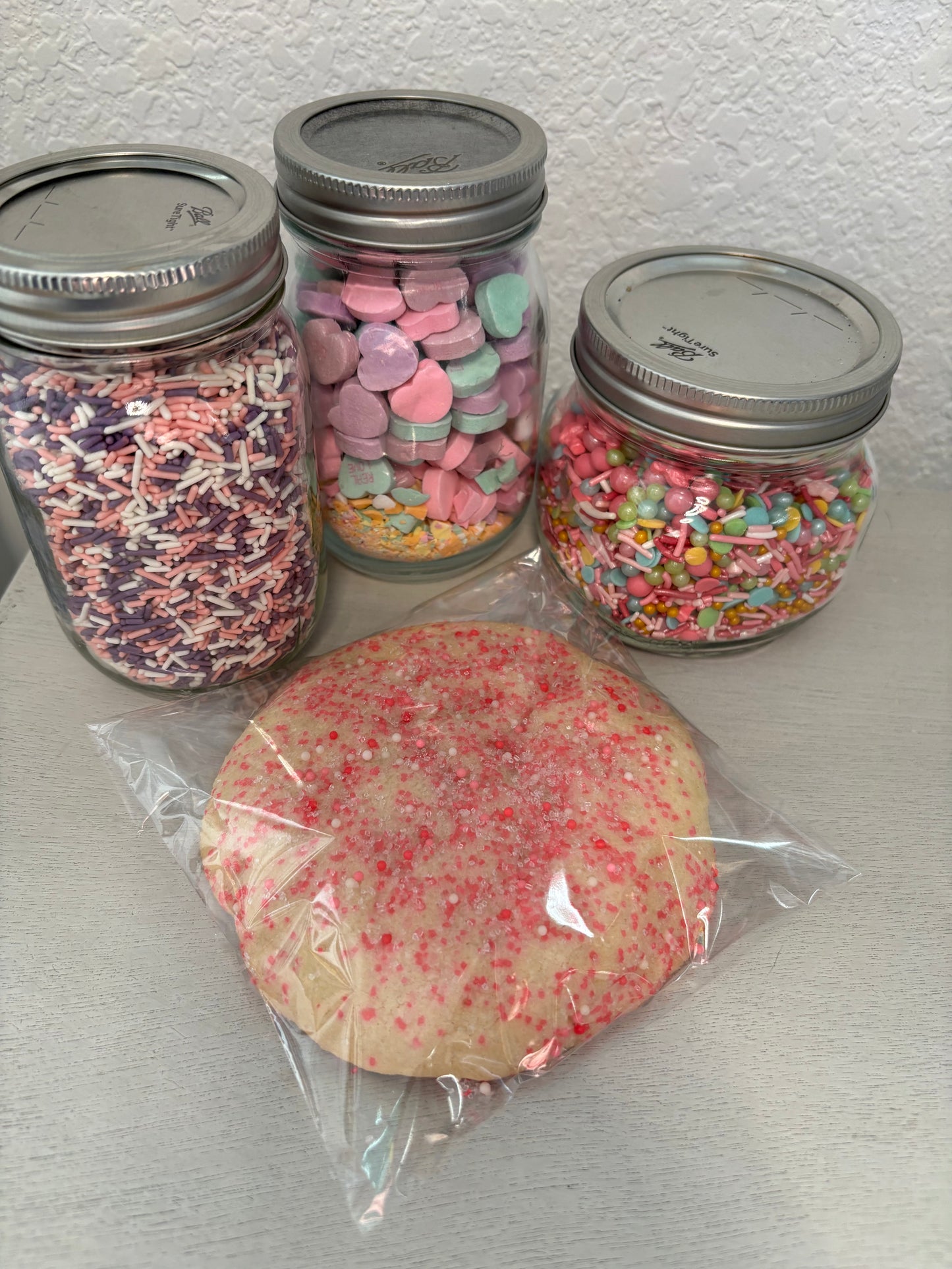 Large sugar cookie with pink sprinkes.