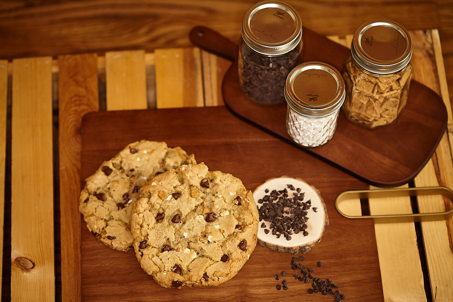 freshly baked chocolate chip smore's cookies on a wooden cutting board