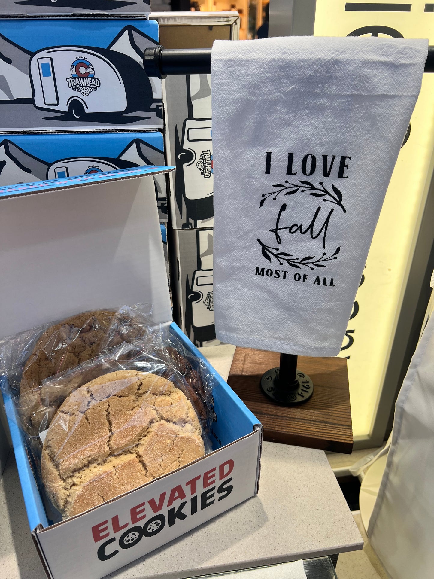 Bakery items including a fall towel with 'I love fall most of all' , cookies, and a box.