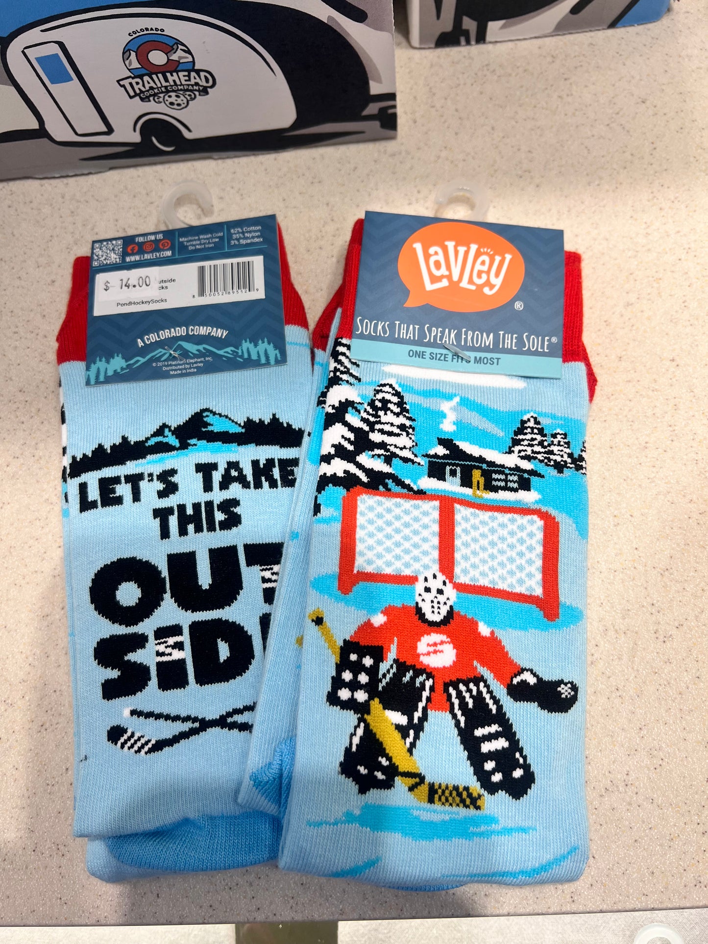 Colorful socks with graphic designs of a hockey goalie and the text "lets take this outside"