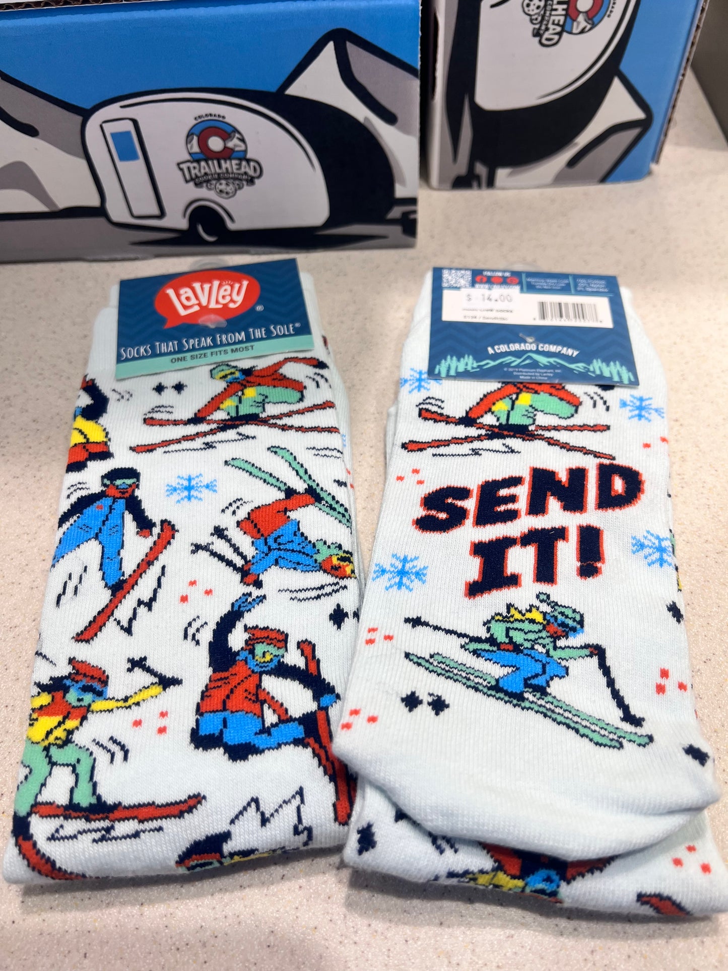 Pair of socks with skiing design and text "send it".
