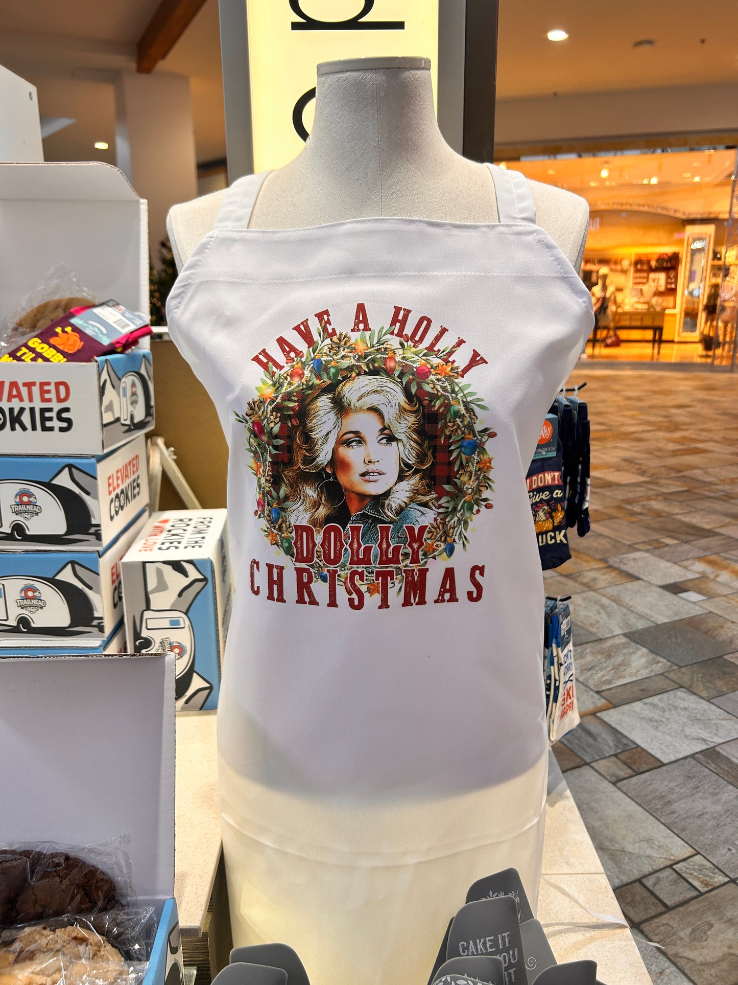 White Dolly Inspired Apron with festive design on a mannequin in a store setting