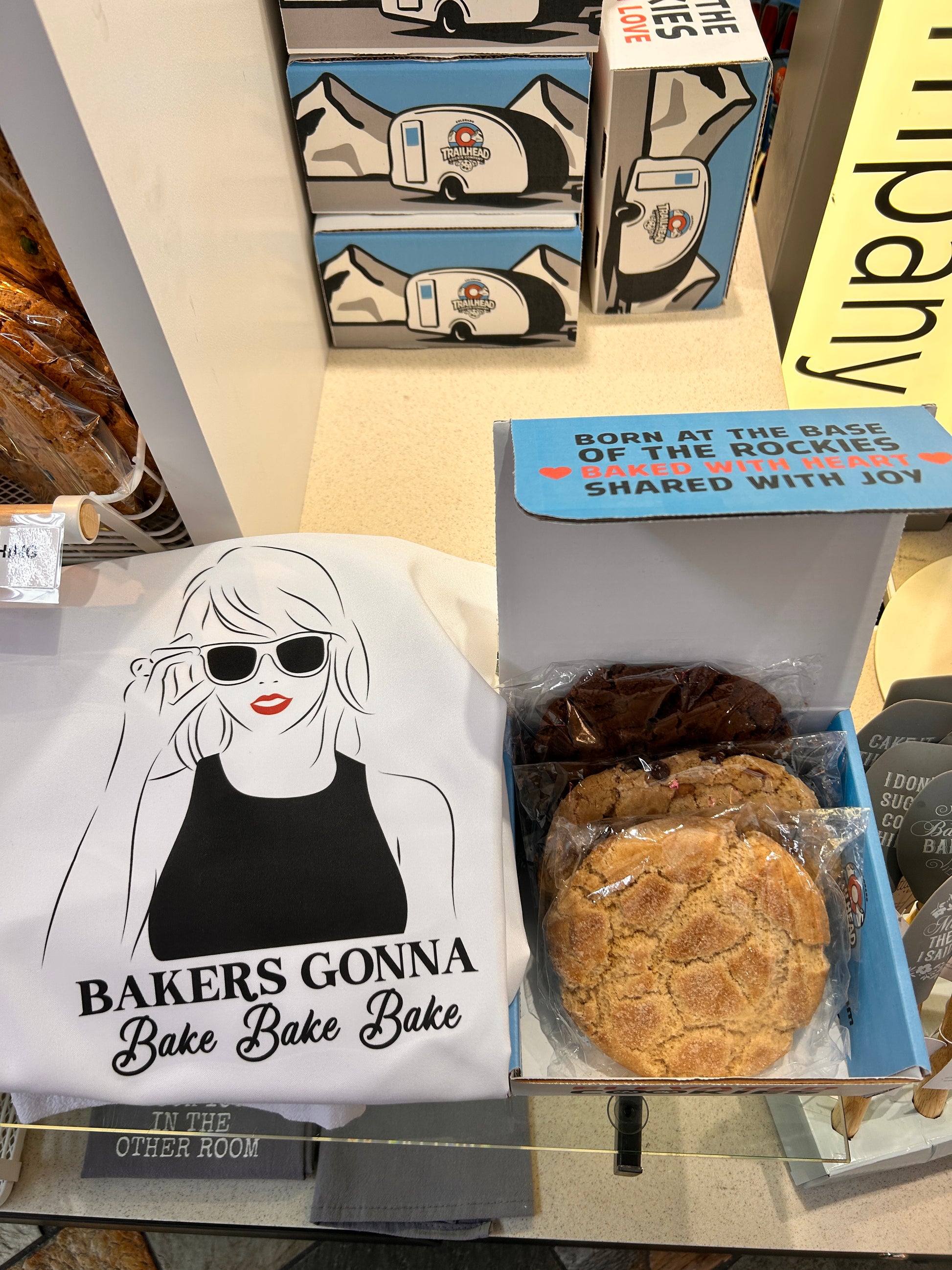 Bakery display with cookies and a t-shirt labeled 'Bakers Gonna Bake Bake Bake Bake All Day Long'.