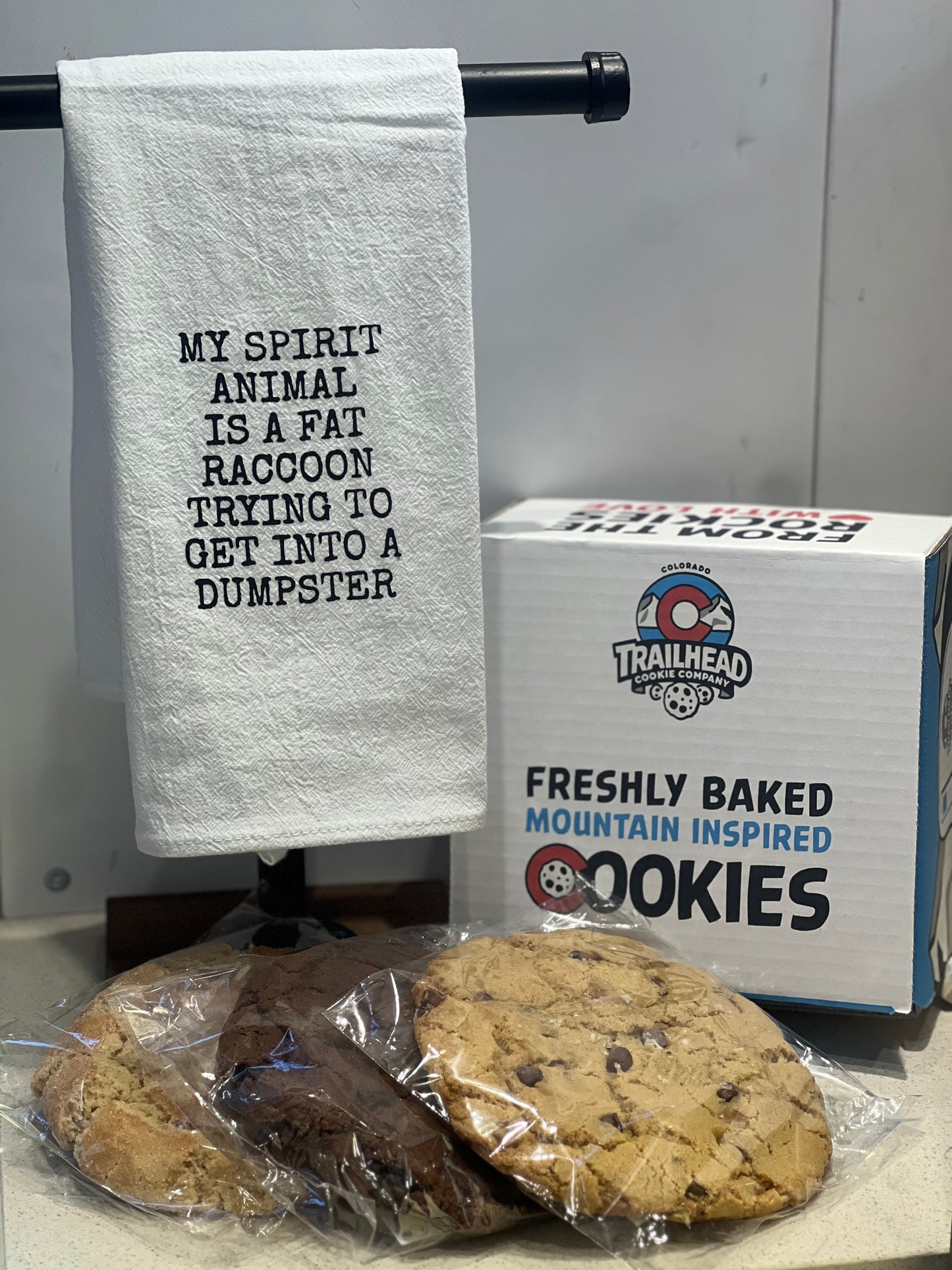 Towel with text, box of cookies, and cookies on a surface