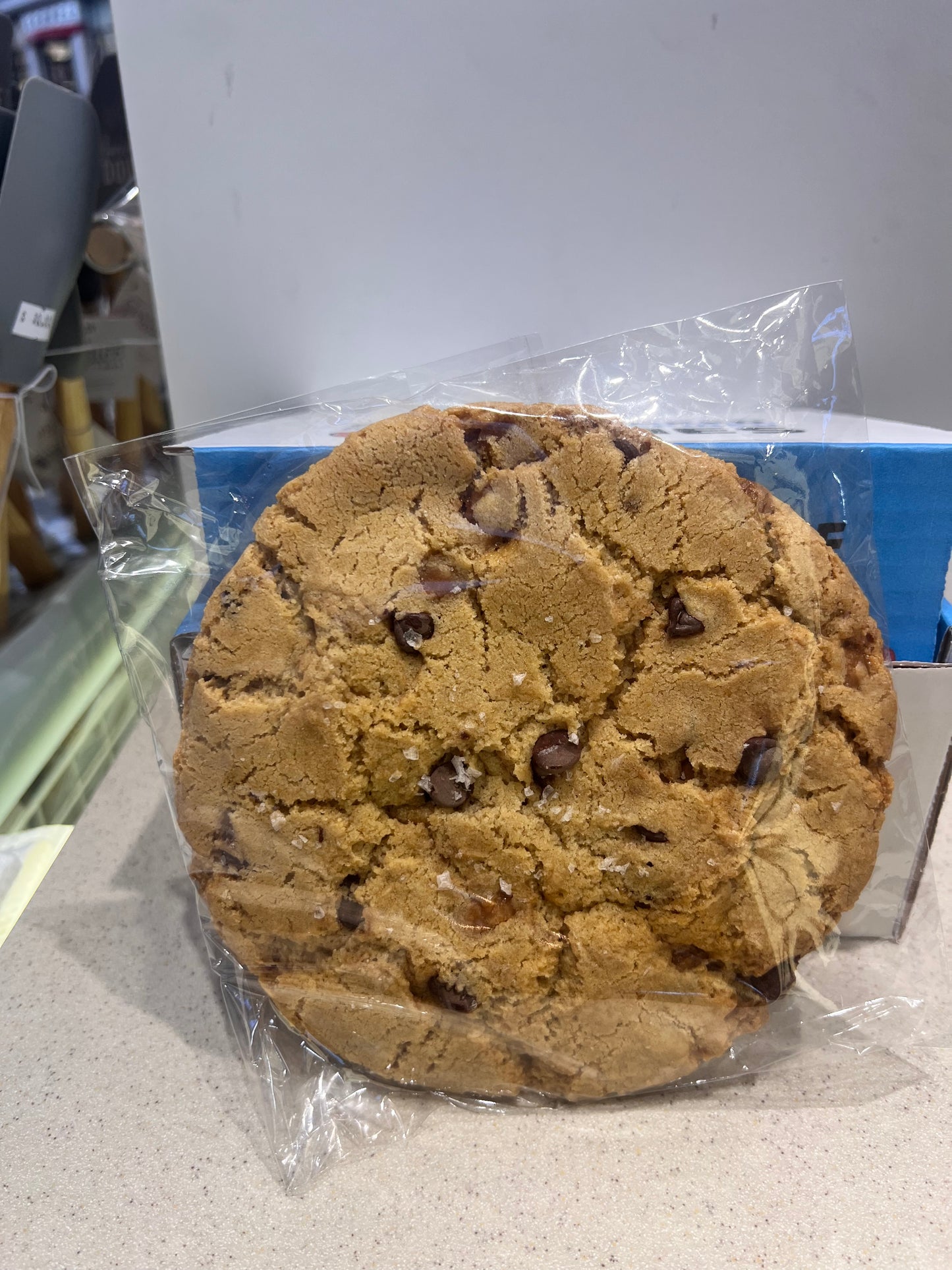freshly baked half pound Chocolate chip cookie in front of a gift box