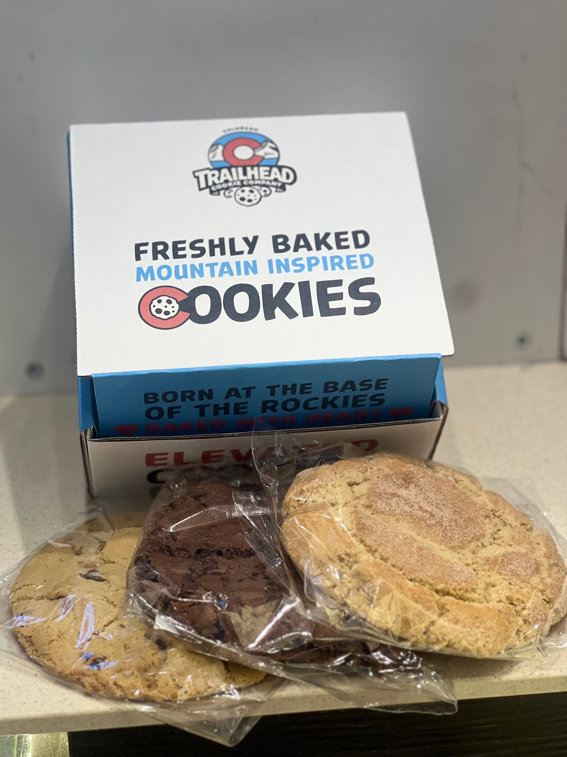 3 half pound fresh based Trailhead cookies with gift box packaging on a shelf